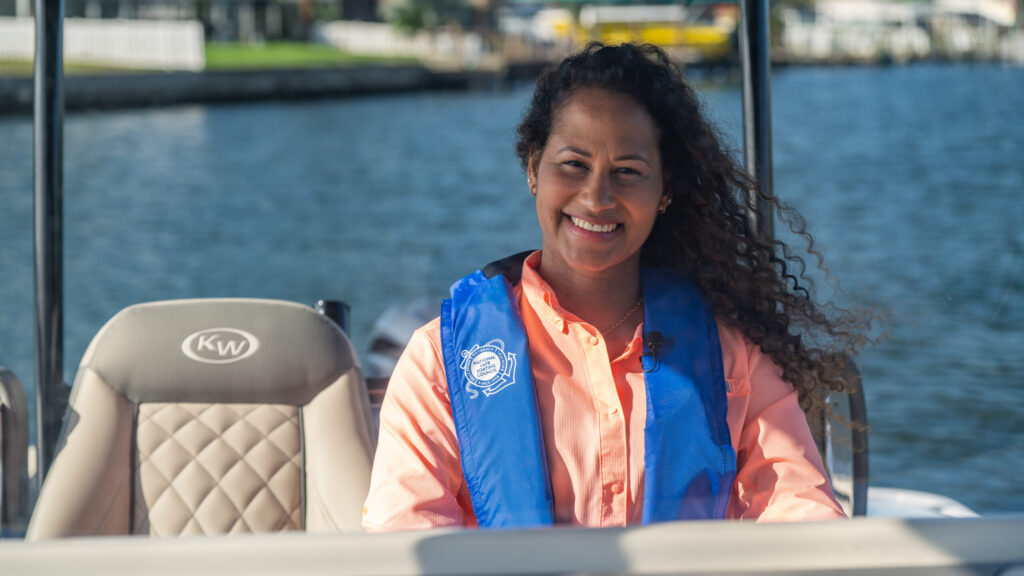 Woman on a boat wearing an NSBC life jacket — National Safe Boating Council photo